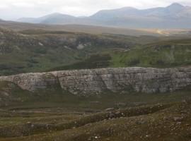 A prominent rock wall, and the Inverlael Forest hills in the distance